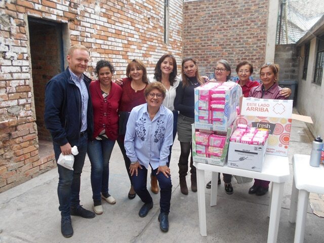 A group of people outside a prison delivering menstrual supplies