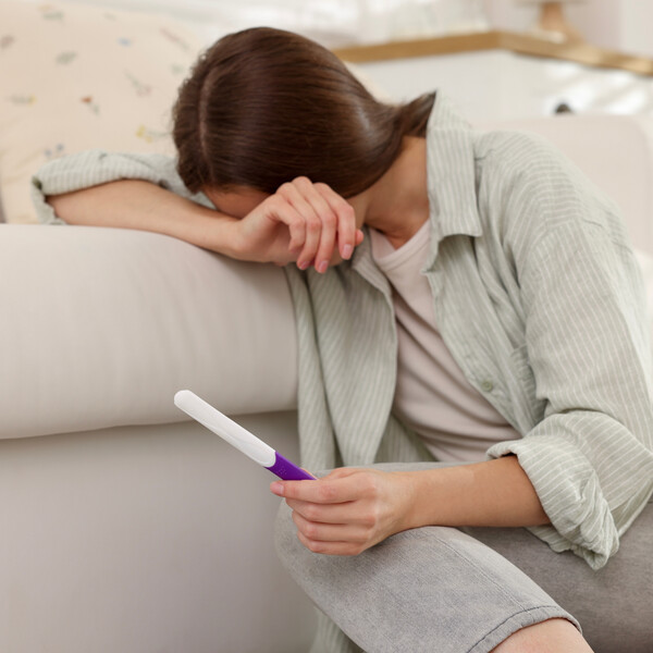 A woman cries over a pregnancy test
