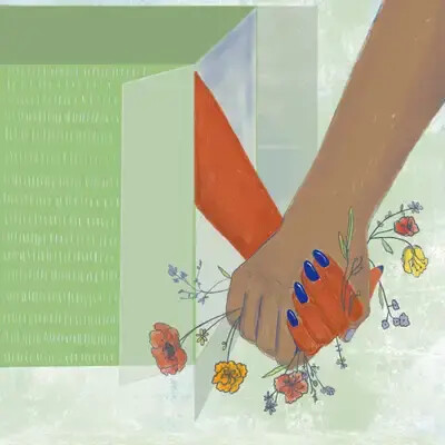 Two hands clasped together with flowers