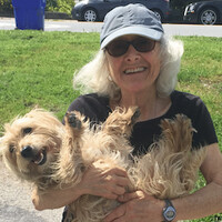 A close up photo of Jill Steinberg holding a dog