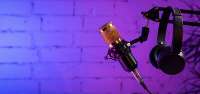 Microphone and headphones against a purple brick wall