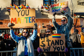Activists stand in front of Stonewall Inn with signs that read "You Matter," "We Stand w/ You," "Love is... equal, kind, love is love."
