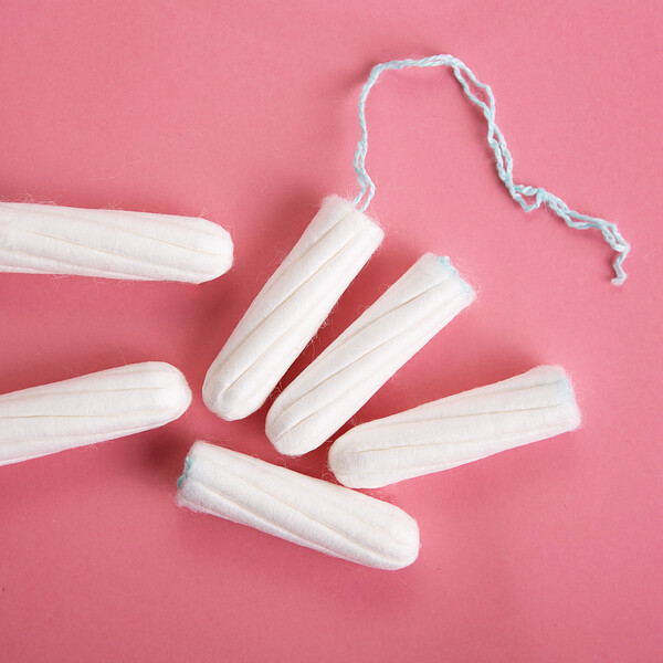 A pink background with a pile of tampons