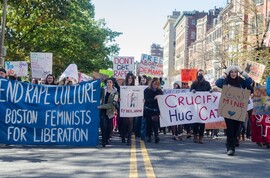 Women walk down the street in a protest against rape culture.
