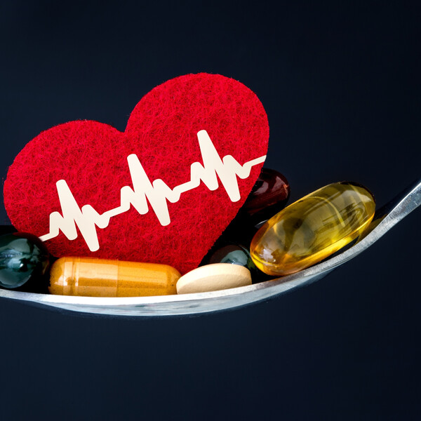 A spoon with pills and a small felt heart