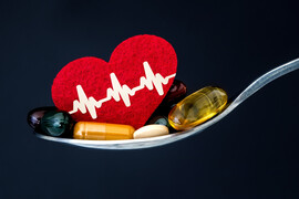 A spoon with pills and a small felt heart