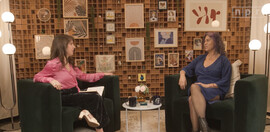 Two women sit together having a conversation