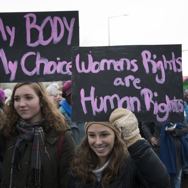 Two women at a protest. One holds a sign saying, "My Body My Choice" and the other holds a sign saying, "Women Rights and Human Rights."
