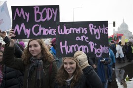 Two women at a protest. One holds a sign saying, "My Body My Choice" and the other holds a sign saying, "Women Rights and Human Rights."