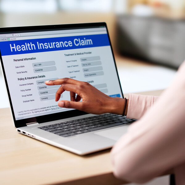 A laptop with a health insurance claim form on the screen