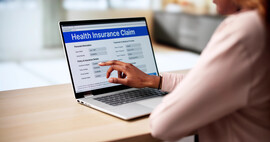 A laptop with a health insurance claim form on the screen