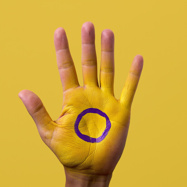 A hand painted yellow with a purple circle on it, appearing to be the intersex flag