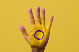 A hand painted yellow with a purple circle on it, appearing to be the intersex flag