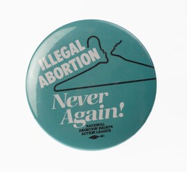 A teal button with a coat hanger and the words "Illegal Abortion Never Again"