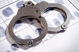 handcuffs laying on fingerprints chart