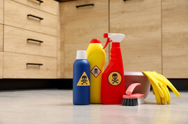 Toxic household cleaners in front of a cabinet