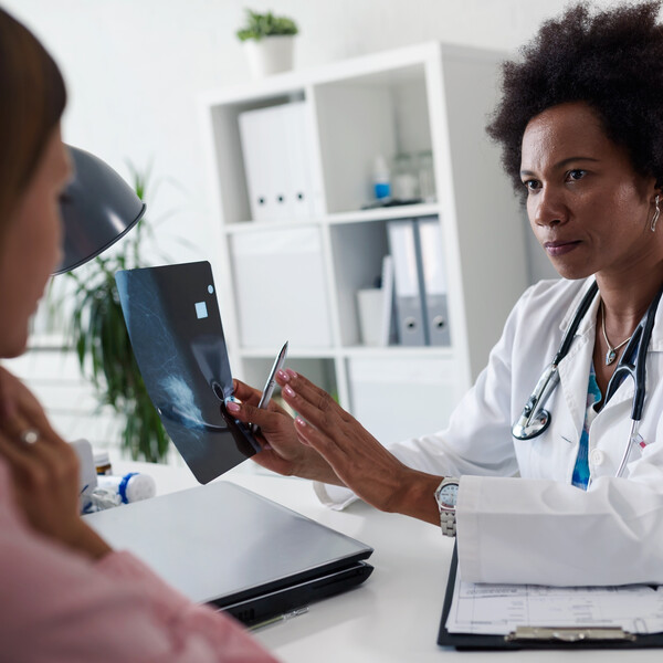 A woman sits in front of her doctor to discuss her mamogram