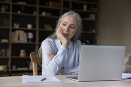 Older woman on computer with concerned look on her face