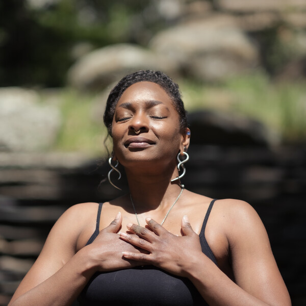 Genderqueer/nonbinary person meditating outside