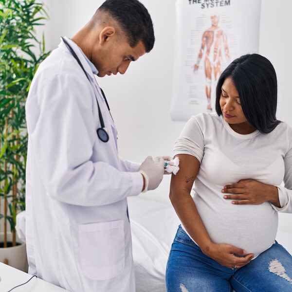 Pregnant woman of color getting a vaccine