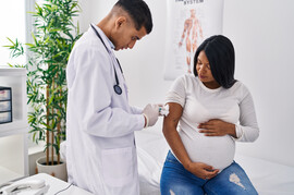 Pregnant woman of color getting a vaccine