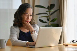 Older Asian woman on a laptop