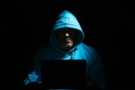 Man on computer in dark room