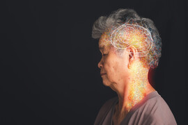 A profile of an older Asian woman with a white brain drawn on her head and colors around it