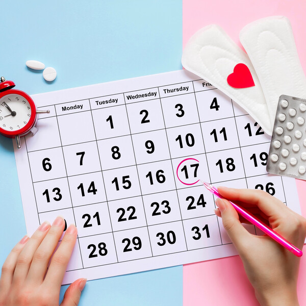 A calendar with a date circled, pads, pills, and a clock
