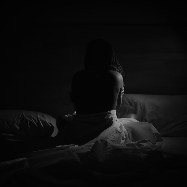 Ahmed ashhaadh woman on bed in dark room unsplash scaled jpg