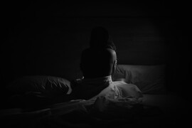 Ahmed ashhaadh woman on bed in dark room unsplash scaled jpg