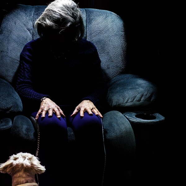 Camellia faceless older woman in chair in dark unsplash scaled jpg