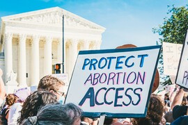 Protest in Washington, D.C. in support of abortion rights. Close up on a protest sign. A blue trimmed sign says "Protect Abortion Access”.
