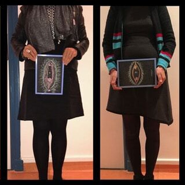 Four people are seen from the chest down. They each hold different painted images of vulvas in front of themselves.