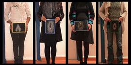 Four people are seen from the chest down. They each hold different painted images of vulvas in front of themselves.