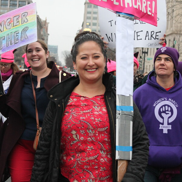 A group of women carrying signs with messages including "Stronger Together" as participants in the Women's March Rally in 2017.