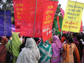 A group of women with their backs facing the camera holding colorful signs.