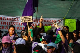 A group of women in Mexico marching and holding signs as part of a demonstration on International Women's Day.