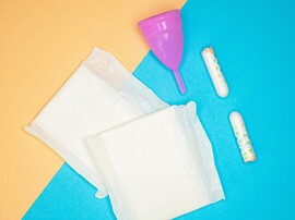 Menstrual health products and supplies (pads, tampons, menstrual cups or reusable cups) on a colorful background.