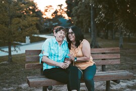 Two women sitting and laughing on a bench.