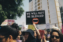 People rallying in the street at the Kuala Lumpur Women's March, 2019. One sign reads "We will not be silenced."