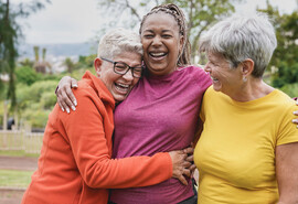 Happy multiracial senior women having fun together at park.